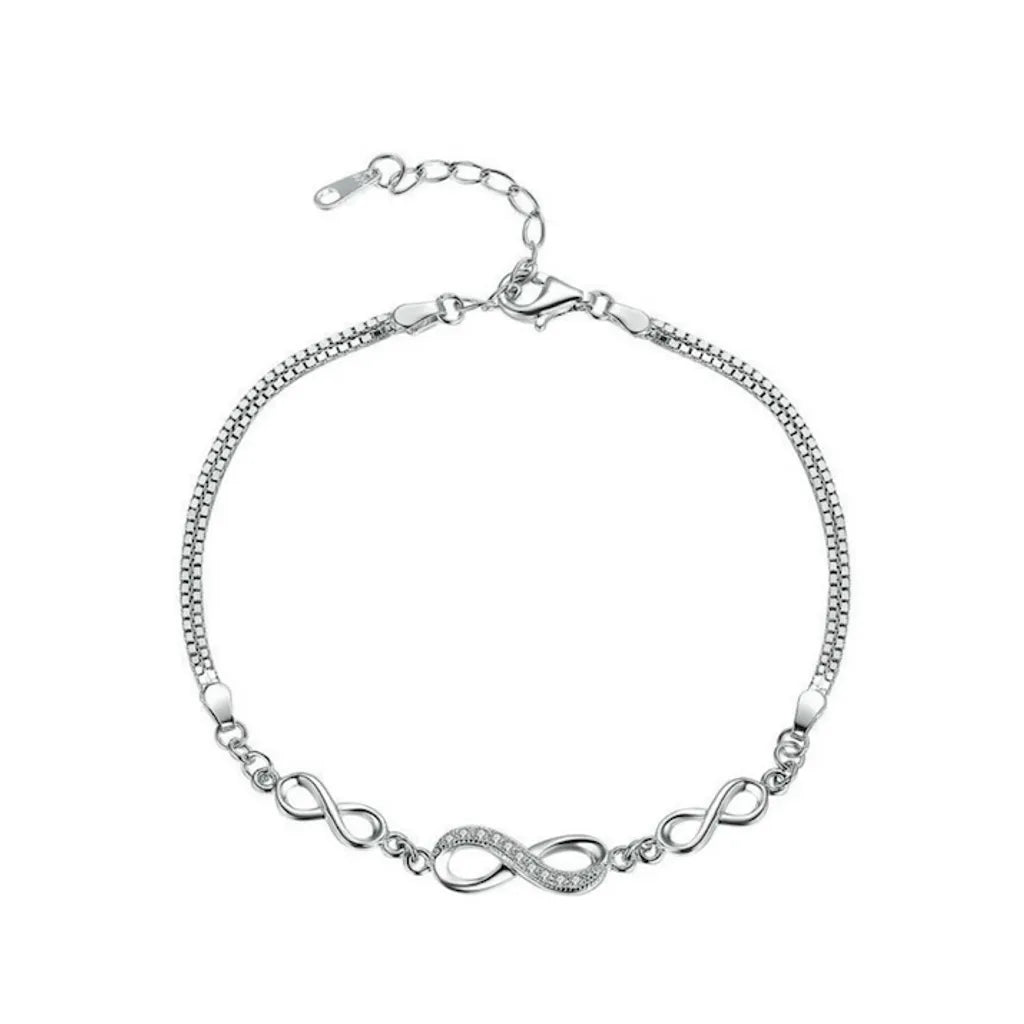 Bracelet Infinita en argent 925 avec trois charms infini, chaîne vénitienne double, fermoir pince de homard et plaquage platine, présenté sur fond blanc.