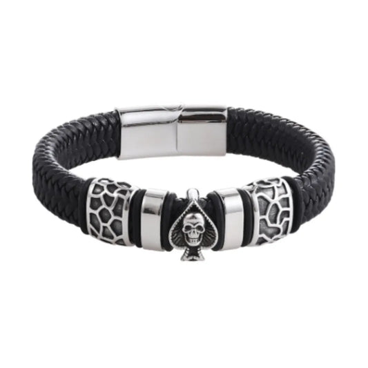 Packshot fond blanc. Le bracelet Kaldor cuir tressé noir en gros plan. Le symbole Pique et Tête de Mort en acier poli, emblème de l'audace.