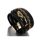 Bracelet multilanière mauvais œil Miyuki, wrap en cuir PU noir présenté droit, reposant sur son fermoir magnétique en alliage de couleur or, style bohème pour femme.