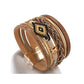 Bracelet multilanière mauvais œil Miyuki, wrap en cuir PU beige, or et marron présenté droit, reposant sur son fermoir magnétique en alliage de couleur or, style bohème pour femme.