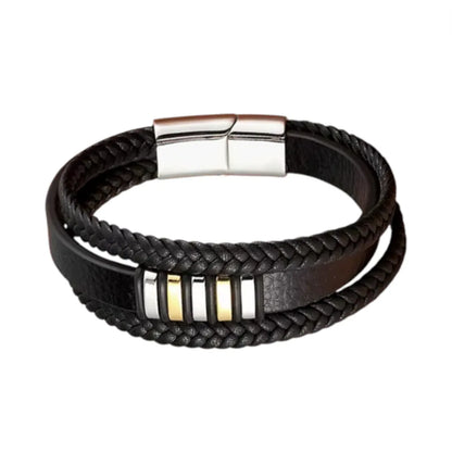 Vue de face. Le bracelet Nexus cuir noir multi-rangs offre une profondeur visuelle par l'assemblage bicolore argent et or sur fond neutre.