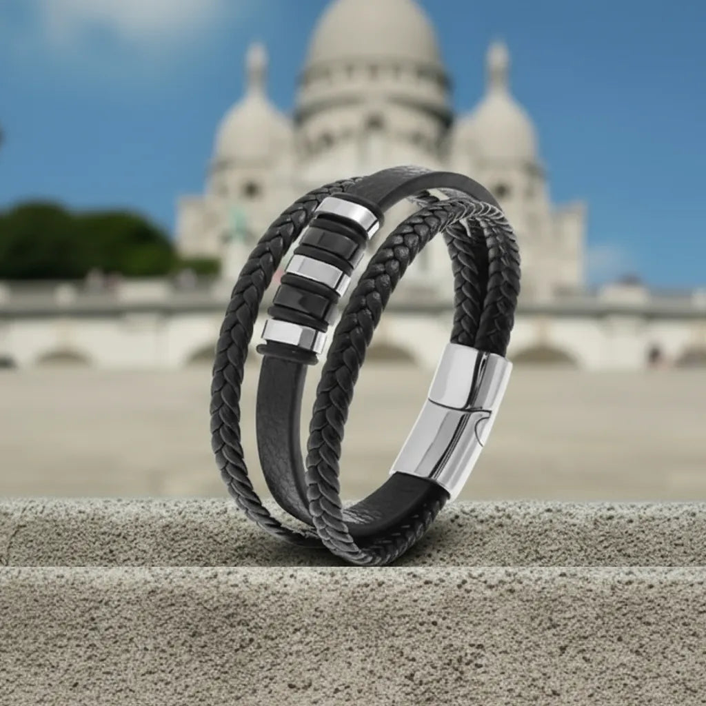 Architecture en mouvement. Le bracelet Nexus cuir noir multi-rangs repose sur la pierre d'une marche devant le Sacré Cœur.