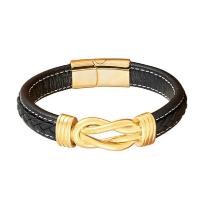 Gros plan. L'éclat du nœud entrelacé doré sur le bracelet Noxus, soulignant la richesse du cuir noir tressé.