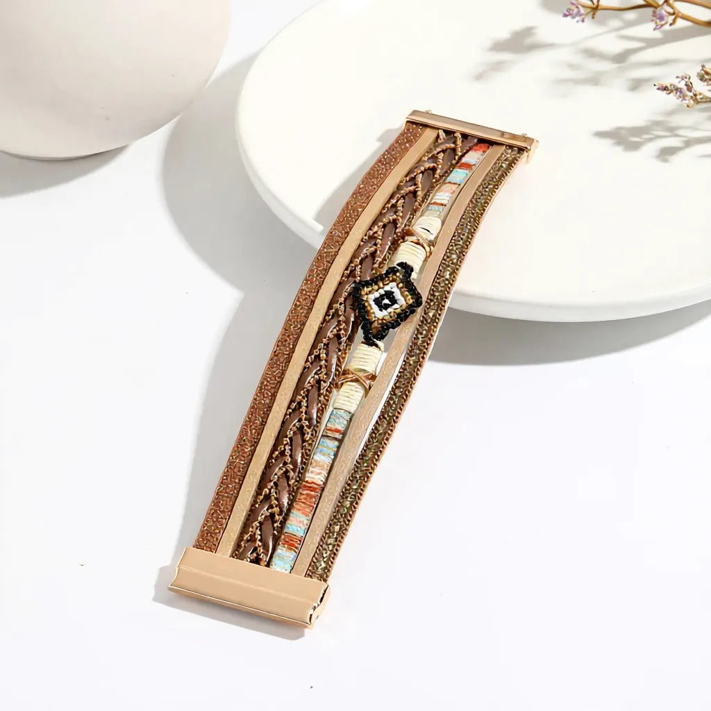 Bracelet Œil du Chaman amérindien multi-rangs en cuir microfibre, ouvert à plat sur une assiette en céramique, révélant ses motifs tressés et perles.