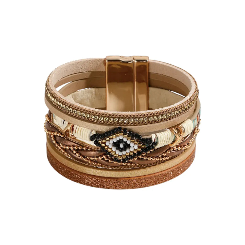 Bracelet Œil du Chaman en cuir microfibre beige et doré, multi-rangs avec perles pony beads, strass et chaîne à bille, fermoir magnétique style amérindien.