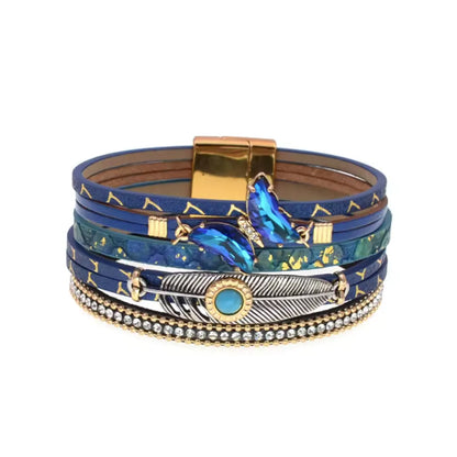 Bracelet bleu marine avec plume Quetzal et breloques papillon, pour une touche de mystère.