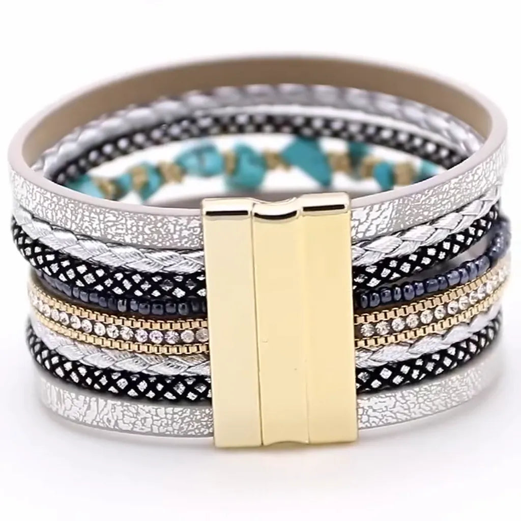 Gros plan du fermoir magnétique doré d'un bracelet Pierre Horizon, avec cuir microfibre argenté, strass et perles noires sur fond blanc.