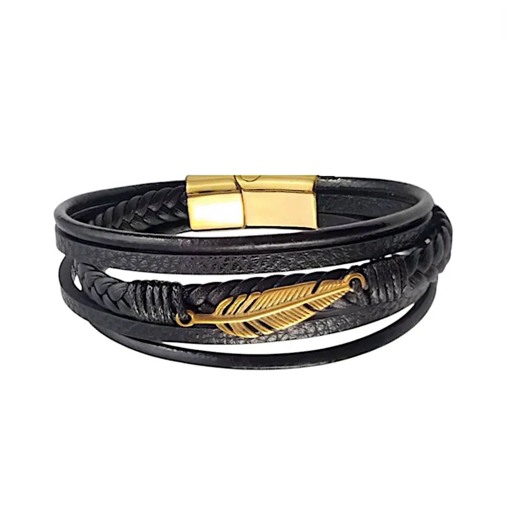 Bracelet en cuir noir multi-rangs avec plume Liberté dorée, posé de face sur fond blanc. Le fermoir magnétique doré est visible en arrière-plan.