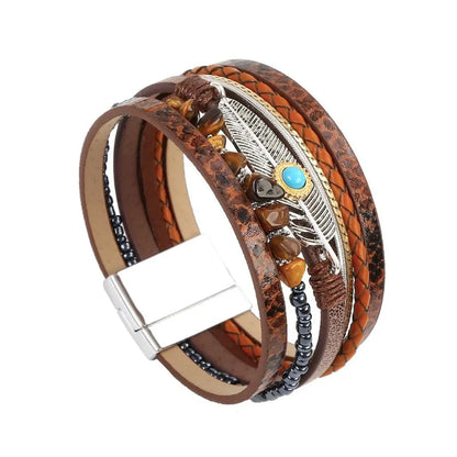 Vue latérale du bracelet marron multi-rangs, mettant en lumière le fermoir magnétique argenté et la breloque plume en arrière-plan.