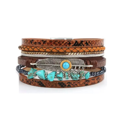 Bracelet Plume Quetzal marron, multi-rangs cuir microfibre cognac, imprimés serpent, plume ajourée, cabochon bleu cerclé doré, cordon tressé et rang perlé turquoise.