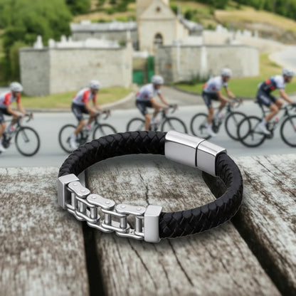 Vue de performance. Le bracelet Pulsar cuir tressé noir posé à plat, ses maillons reflétant l'effort des coureurs cyclistes. Le symbole de la mécanique du mouvement.
