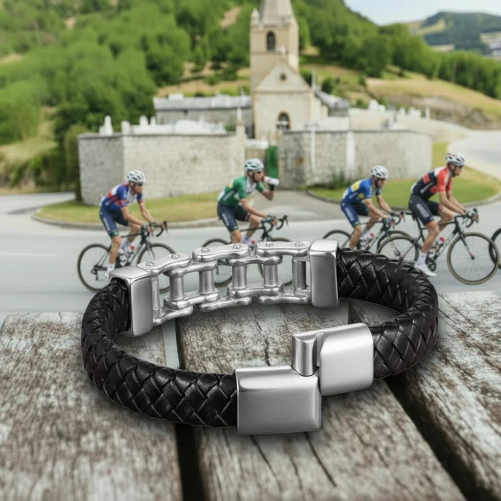 Détail de sécurité. Le bracelet Pulsar cuir tressé noir, fermoir entrouvert, mettant en valeur la chaîne de vélo en acier. L'élégance du cuir tressé sur fond de montagne.