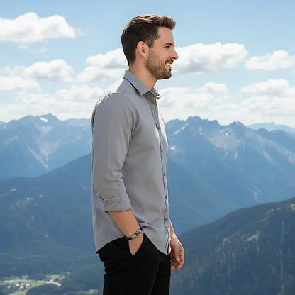 Bracelet Ouroboros en cuir noir porté au poignet d'un homme. Il est vu de profil, vêtu en gris et noir.