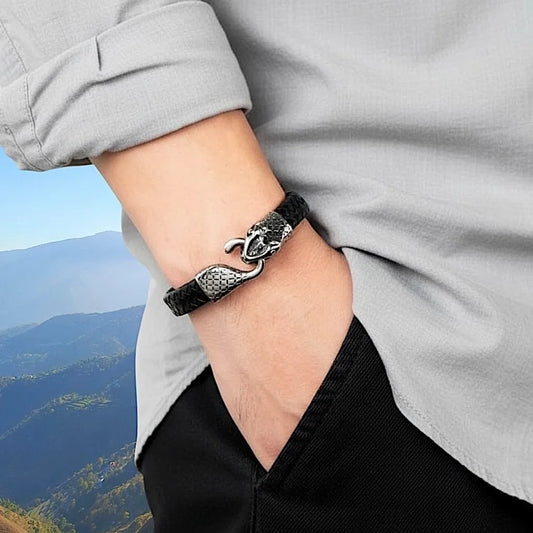 Bracelet Serpent Ouroboros en cuir noir porté par un homme. Vue de profil sur son poignet, avec le fermoir apparent.