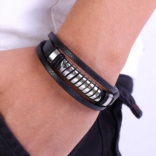 Bracelet spirale acier avec perle tube ajourée, argentée et multilanère en cuir noir, présenté autour d'un poignet d'homme.