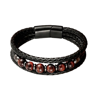 Vue de face du bracelet Talis, mettant en valeur l'énergie des perles œil de tigre rouge et noir. L'acier inoxydable noir du fermoir souligne la construction technique.