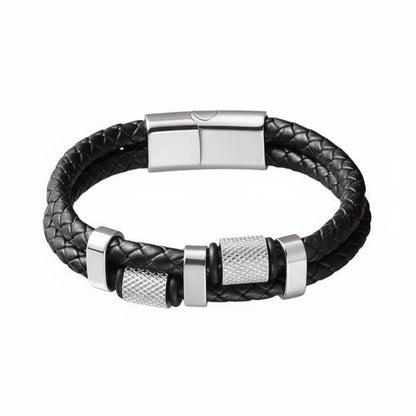 Packshot fond blanc. Le bracelet Talon cuir tressé noir et ses cylindres moletés en acier inoxydable poli. Le symbole de la précision mécanique et du grip industriel.