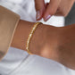Bracelet tennis à maillons Miami en acier inoxydable plaqué or avec rivière zircone cubique - bracelet chaîne présenté sur un poignet de femme