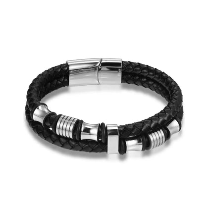 Packshot minimaliste. Le bracelet Thao en cuir noir tressé avec perles diabolo argentées illustre une architecture des formes parfaite.