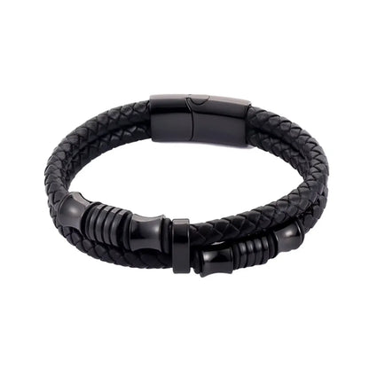 Gros plan. L'équilibre du bracelet Thao Cuir Noir Tressé est mis en valeur, contrasté par la densité du fermoir magnétique noir poli.