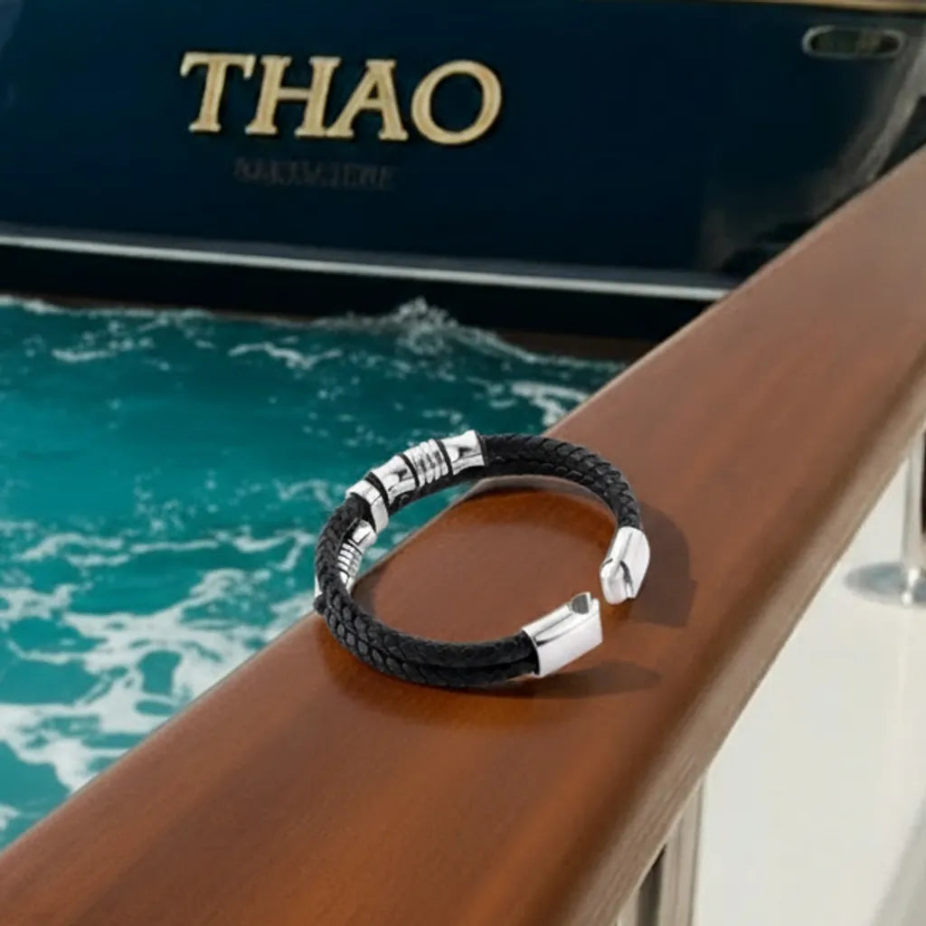 Détail technique. Les perles diabolo sont visibles à côté du fermoir magnétique ouvert, illustrant la robustesse du bracelet Thao près de l'eau agitée.