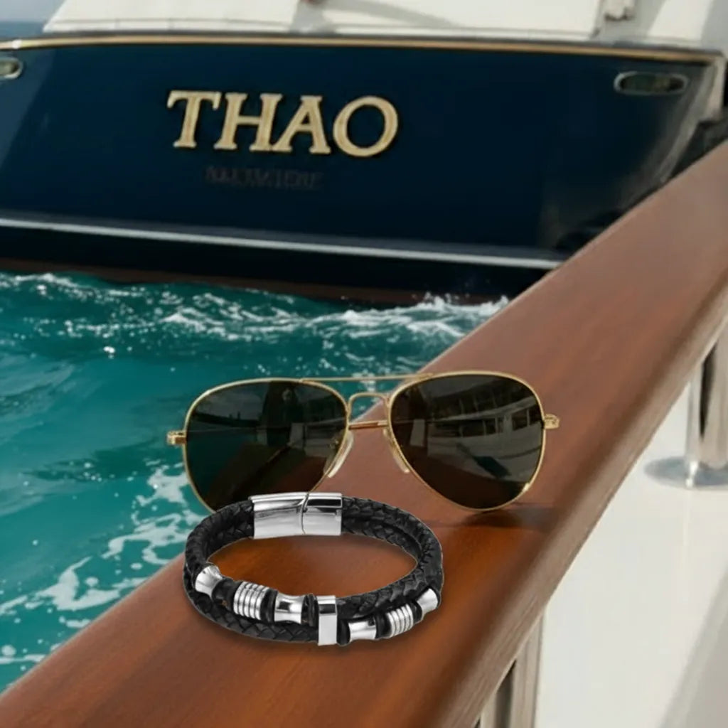 Style nautique affirmé. Le bracelet Thao Cuir Noir Tressé est associé à des lunettes aviateur. Les perles diabolo soulignent l'attrait distinctif du quai.