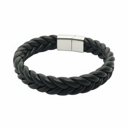 Packshot fond blanc. Le bracelet Torc cuir souple noir avec son tressage rond volumineux à 4 lanières. Le fermoir en acier inoxydable capte la lumière.