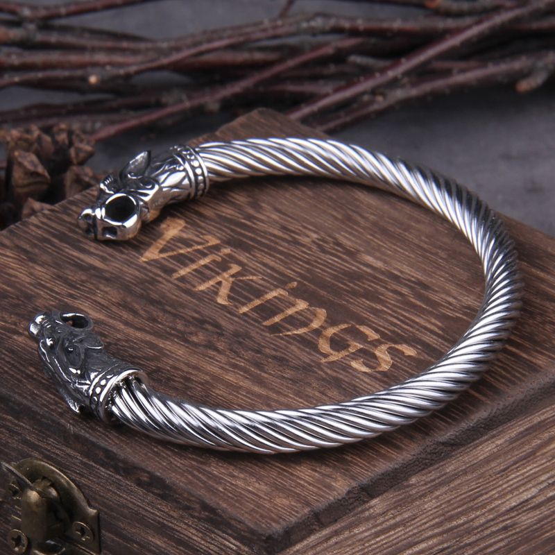 Bracelet manchette viking - Torque avec tête de dragon nordique avec des détails de qualité en acier inoxydable - jonc ouvert torsadé posé sur le dessus d'une boite cadeau en joli bois foncé - couleur du bijou tout argent