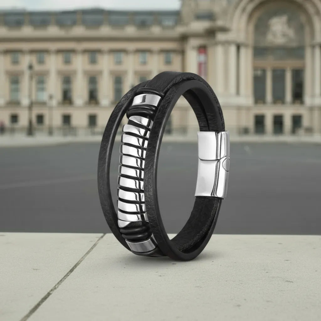 Architecture parisienne. Le bracelet Torus cuir texturé noir en équilibre, soulignant la structure multi-rangs devant le Grand Palais.