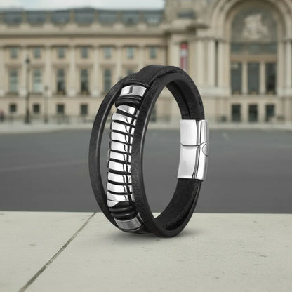 Architecture parisienne. Le bracelet Torus cuir texturé noir en équilibre, soulignant la structure multi-rangs devant le Grand Palais.