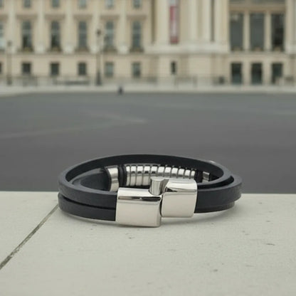 Sécurité et design. Le fermoir magnétique du bracelet Torus entre-ouvert, mettant en évidence la finition de l'acier sur le cuir texturé noir.