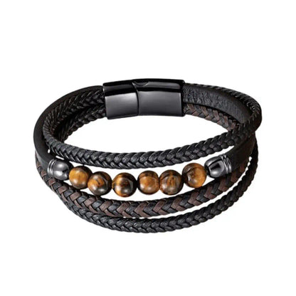 Gros plan frontal du bracelet Vorg révélant l'architecture de ses quatre lanières en cuir et sa rangée de gemmes oeil de tigre aux reflets dorés. L'acier noir du fermoir souligne l'équilibre structurel de cette pièce masculine.