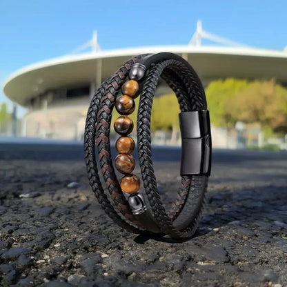 Le modèle Vorg se dresse sur un bitume solaire, mettant en relief l'alignement des gemmes aux reflets dorés. En arrière-plan, les courbes du Stade de France répondent à l'ingénierie des quatre lanières et des embouts d'acier.