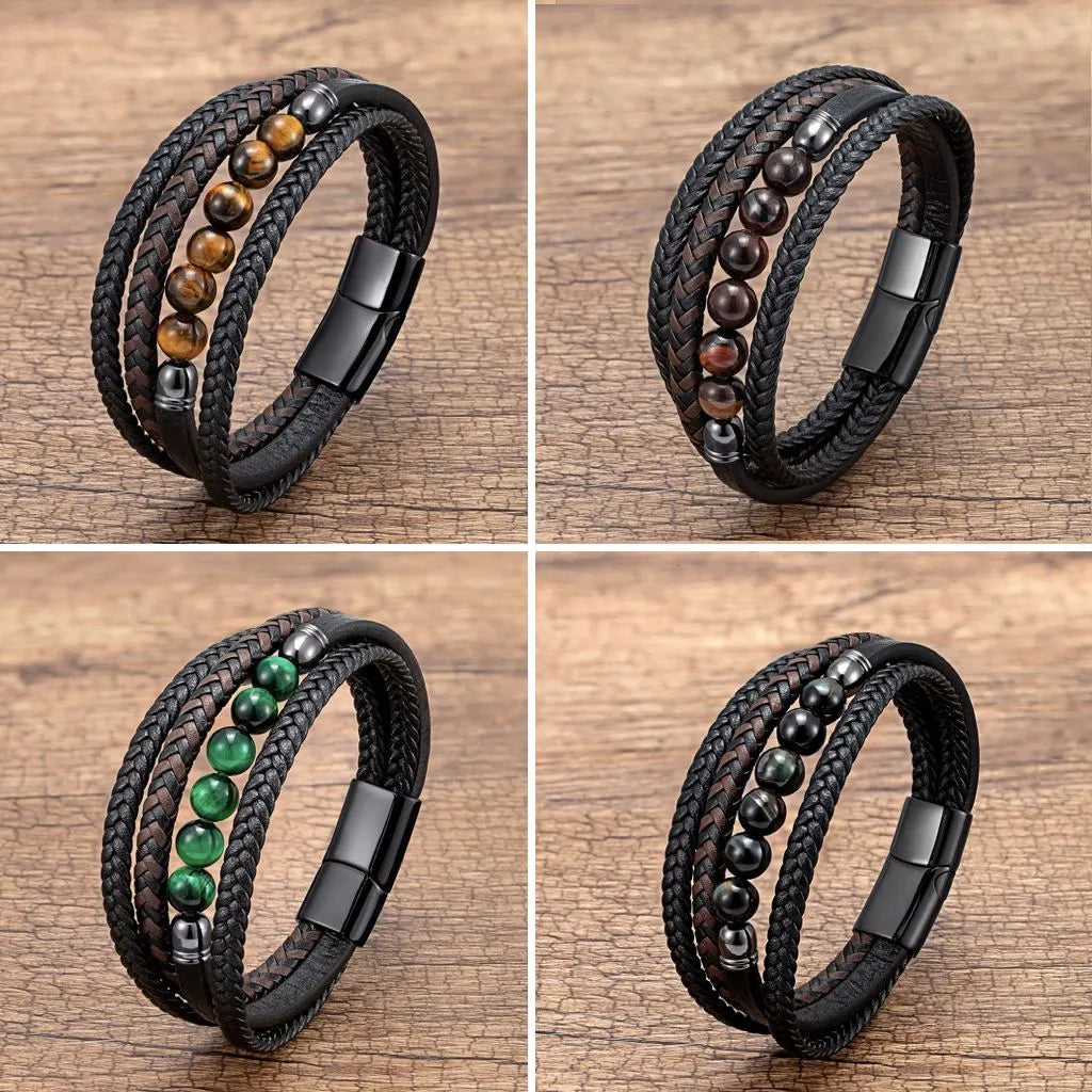 Ensemble de quatre bracelets en cuir tressé noir, orné de perles d’œil de tigre uniques : jaune doré, rouge profond, bleu nuit et vert émeraude. Les bracelets sont alignés en une disposition élégante, mettant en valeur leurs nuances vibrantes et leurs finitions acier noir. Posés sur un fond en bois texturé qui apporte une touche naturelle et chaleureuse, créant un contraste subtil avec le style moderne et raffiné des bracelets. Idéal pour compléter des tenues masculines avec une touche de caractère.