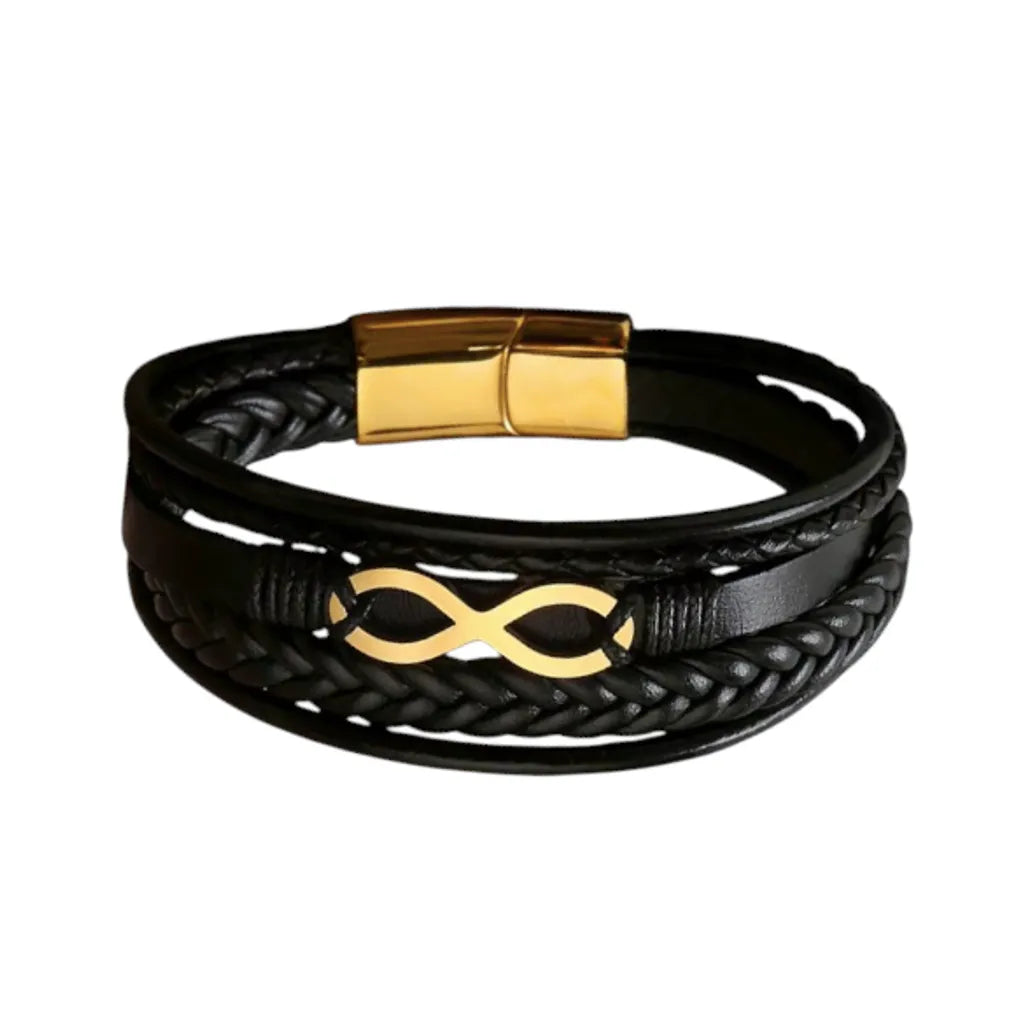 Plan large du bracelet Infini doré. Le cuir structuré noir multi-rangs met en valeur le fermoir magnétique en acier inoxydable doré sur fond blanc.