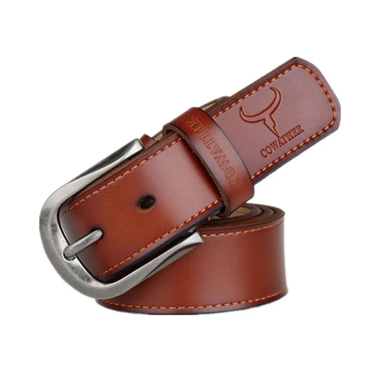 Ceinture pour homme en cuir véritable lisse, lanière en cuir de vachette, surpiqure décorative. Revêtement de protection peint, coloris cognac orangé. Sa boucle ardillon en métal arrondie est argentée et anticorrosion. Logo et marque COWATHER gravé. Présentation fermée et enroulée sur un fond blanc.