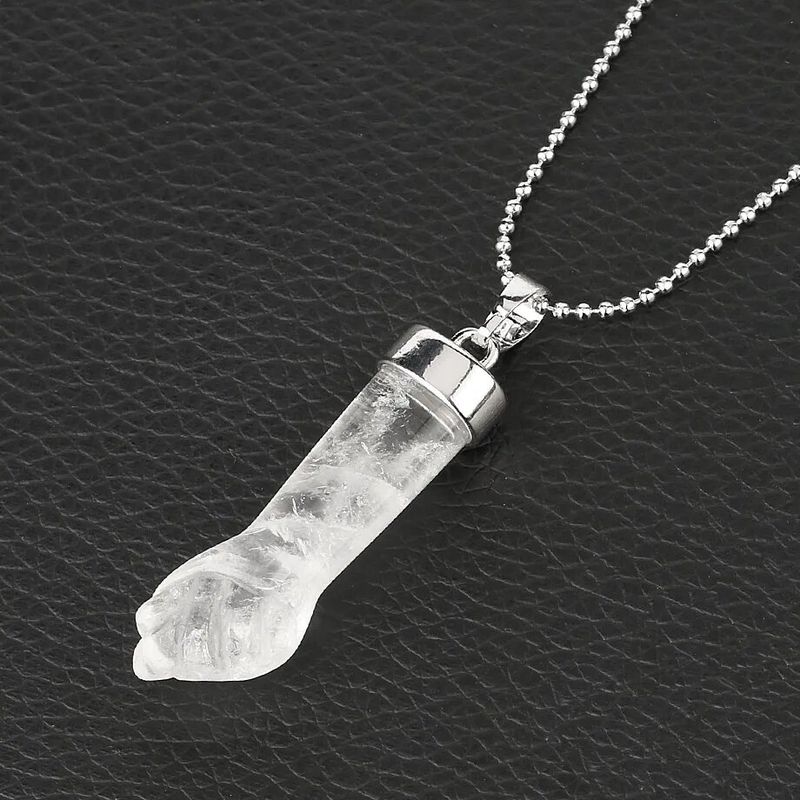 Photo sur fond noir d'un collier pendentif poing serré en plaqué platine et d'une belle pierre naturelle en cristal clair sculptée - chaine à bille argentée