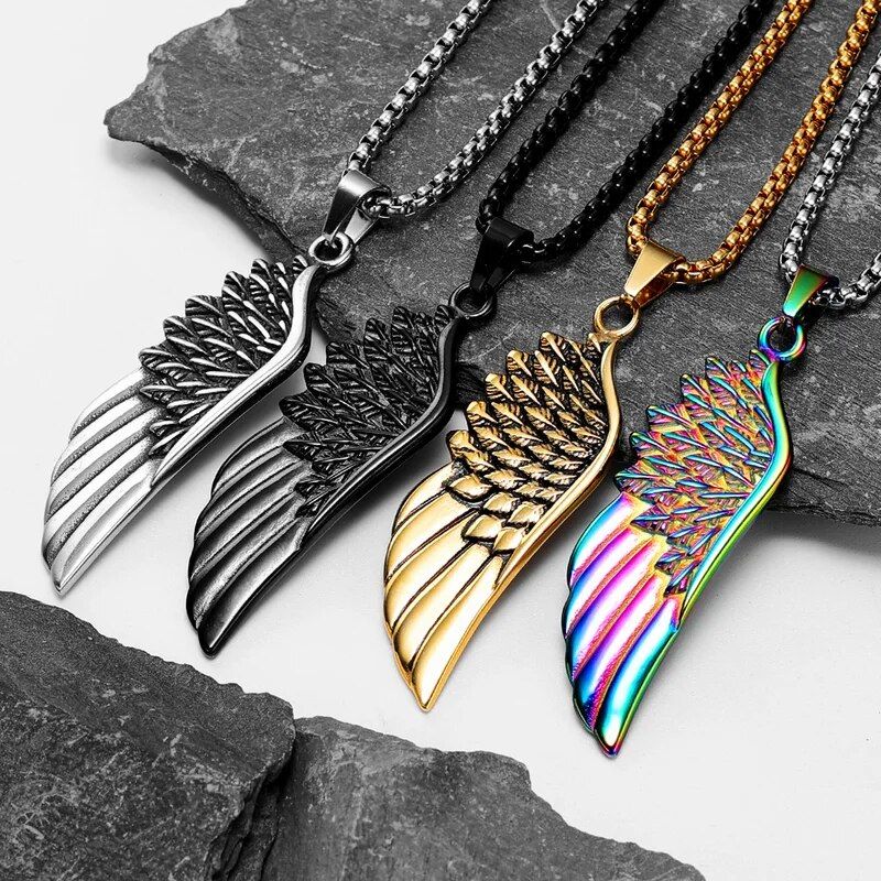 Colliers avec chaine et pendentifs aile d'ange présentés sur une ardoise plate grise -symbole de liberté en acier inoxydable aux détails de qualité - quatre coloris aux choix, en passant du noir, a l'argent, a l'or et aux couleurs de l'arc-en-ciel 