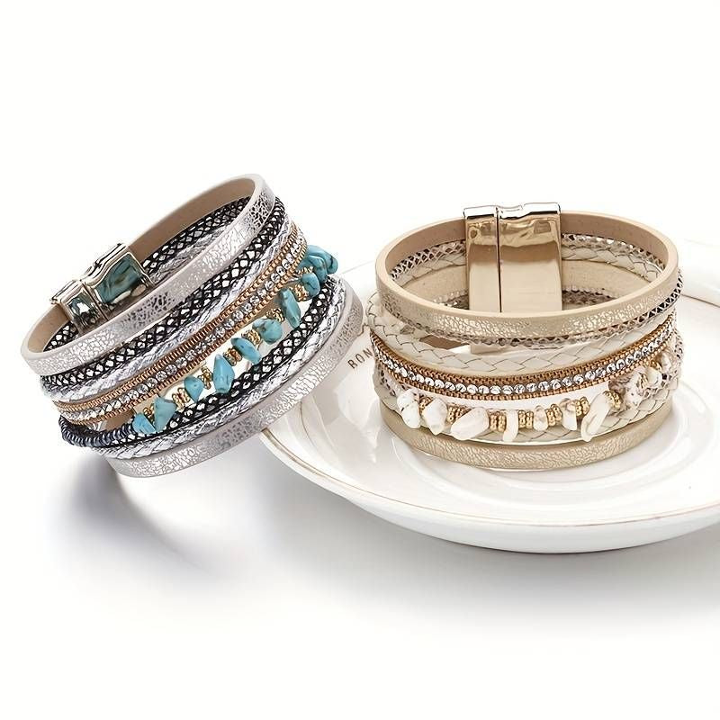 Vue sur deux bracelets bohème, ornés de perles de pierres naturelles bleu turquoise pour le premier wrap incliné sur le bord d'une assiette, le second wrap beige champagne, quand à lui est posé au centre de cette même assiette creuse, multilanière en cuir PU doré ou argenté, strass cristal et fermoir magnétique de couleur assortis.