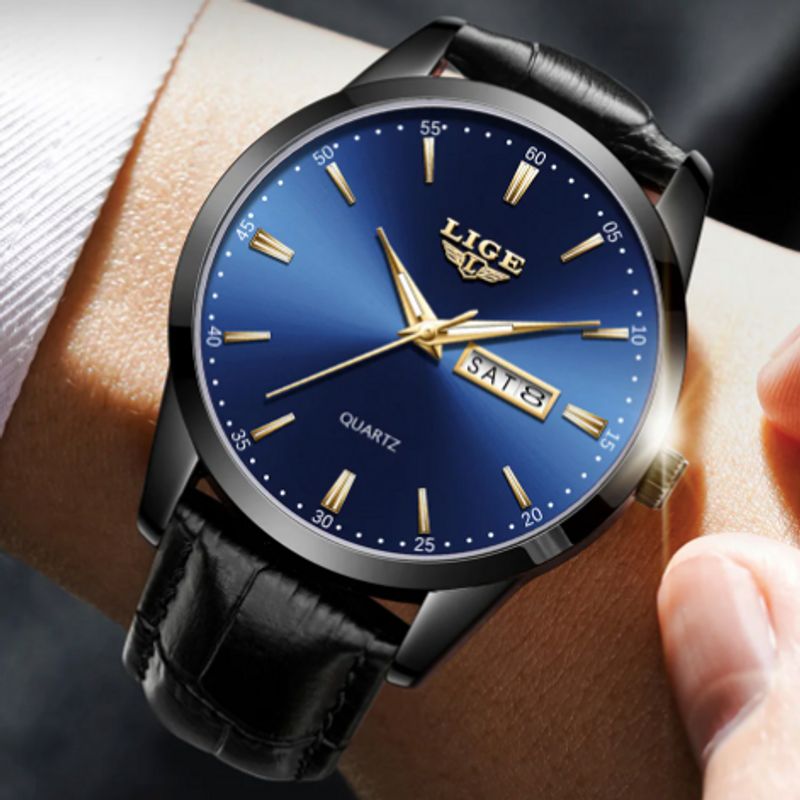 Montre Lige Classic Time présenté un un poignet d'homme vêtu d'une chemise blanche - montre classique avec bracelet cuir noir, son boitier, sa couronne, ses index, et ses aiguilles sont de couleur or - cadran bleu