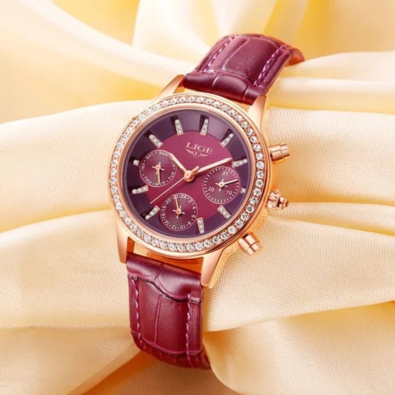 Montre LIGE Diana Cristal bordeaux pour femme avec lunettes aux brillants chic, son bracelet en cuir bordeaux est enroulée autour d'un tissus de couleur jaune.