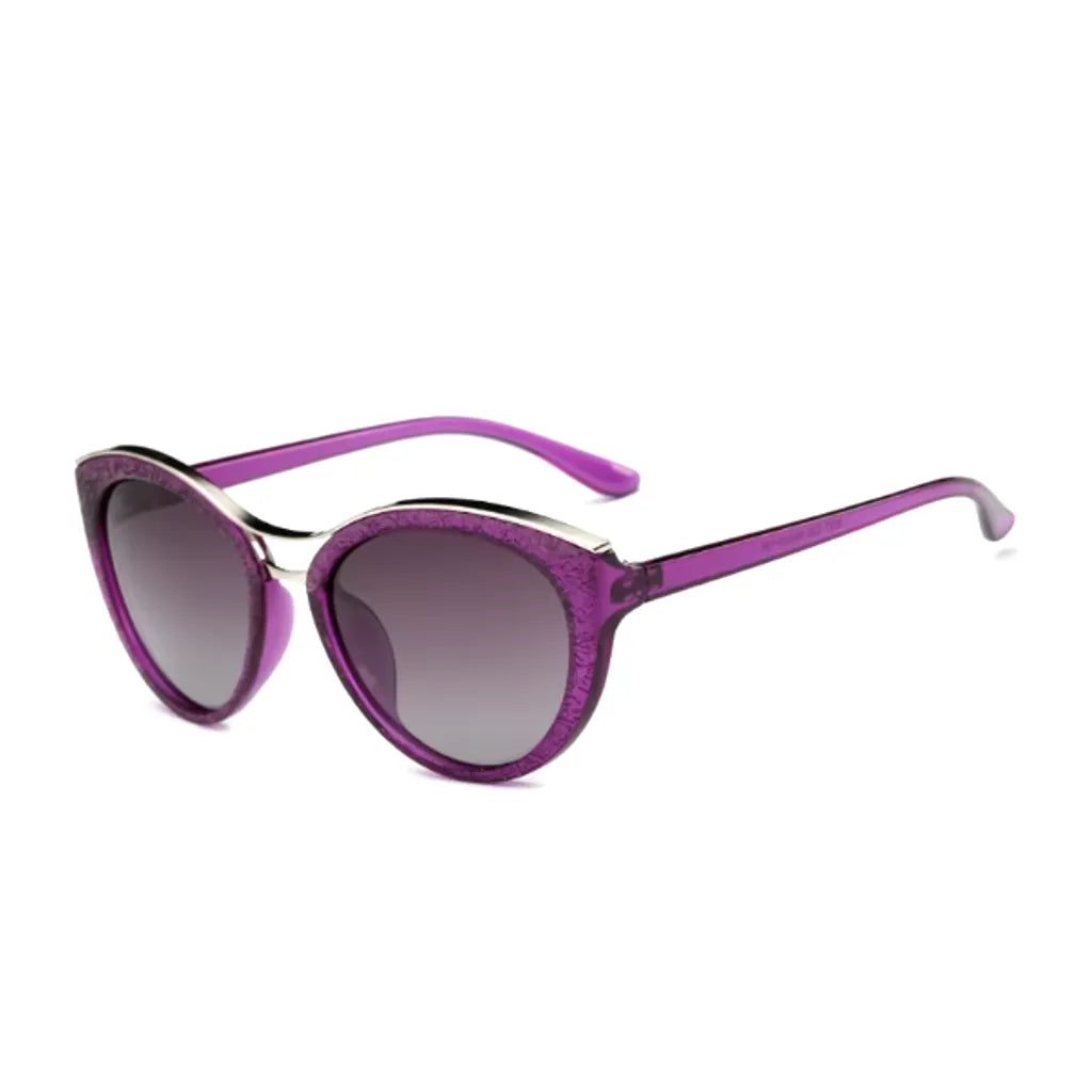 Lunettes de soleil avec une monture mauve en forme de yeux de chat, ornée de détails dorés et de verres dégradés teintés. Ce modèle chic et audacieux offre un style unique, idéal pour ajouter une touche de couleur subtile et élégante aux tenues estivales.