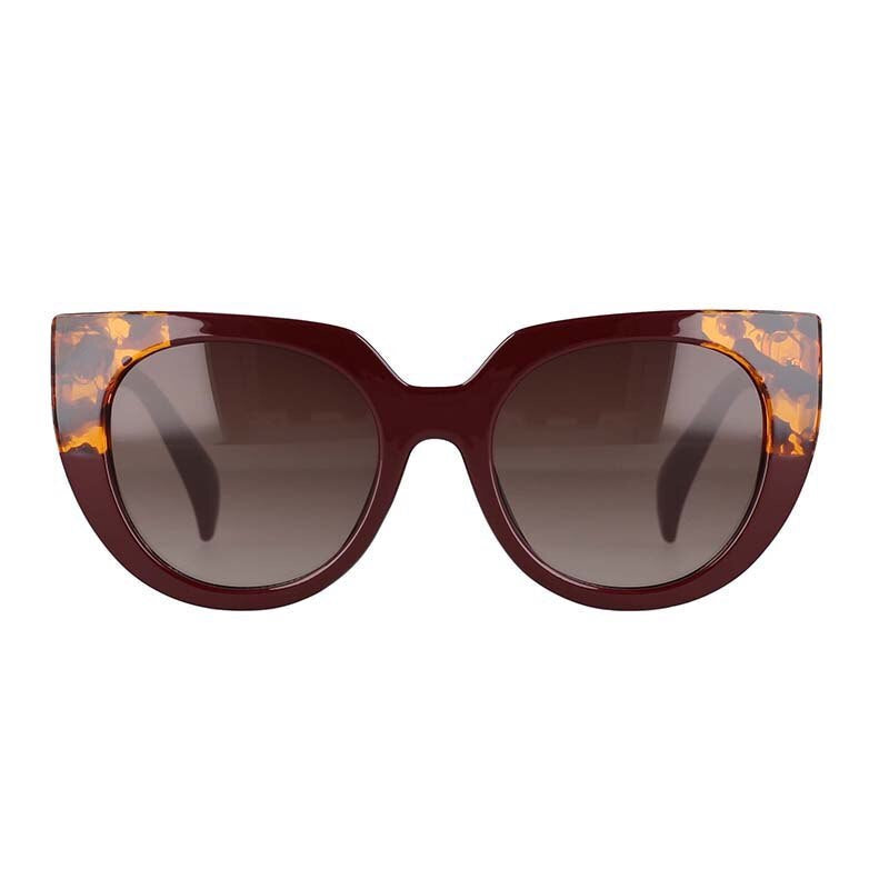 Vue de face, gros plan des lunettes de soleil Bengal à verres ronds et brun clair, monture en forme œil de chat surdimensionnée de couleur ambre et bordeaux pour femme.