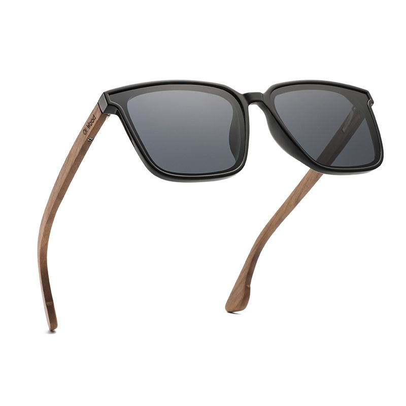 Vue de trois-quart de face d'une paire de lunettes de soleil voyageur avec branches déployées en bois signé de la marque Oi Wood - unisexe - coloris verres polarisés gris - UV400