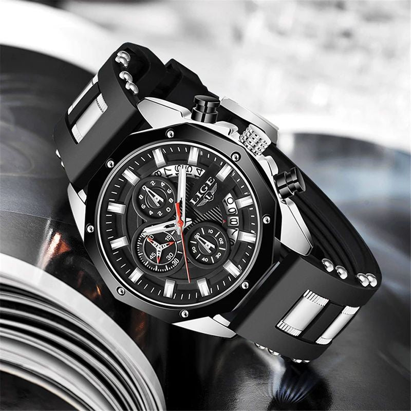 Montre chronographe pour homme présenté incliné sur un album photo vitrifié, son grand cadran est noir, son boiter, ses aiguilles et ses index luminescents sont de couleur acier - le bracelet original est en silicone noir -modèle Lige oceanmaster