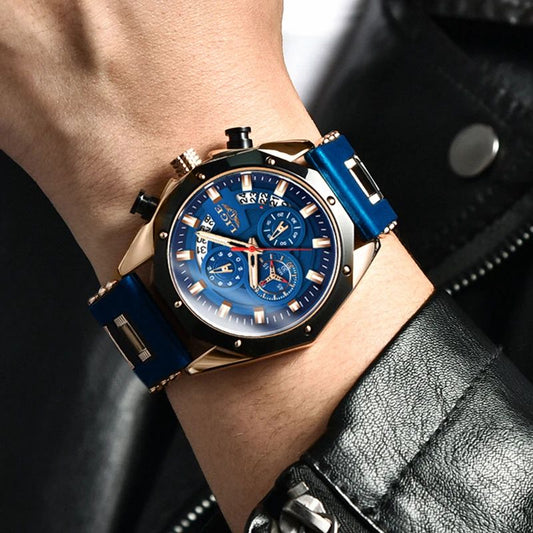 Montre chronographe avec grand cadran bleu présenté sur un poignet d'homme vêtu d'une veste en cuir, son boitier, ses aiguilles, sa couronne et sa boucle ardillon sont de couleur or, son bracelet souple en silicone est bleu - Lige OceanMaster