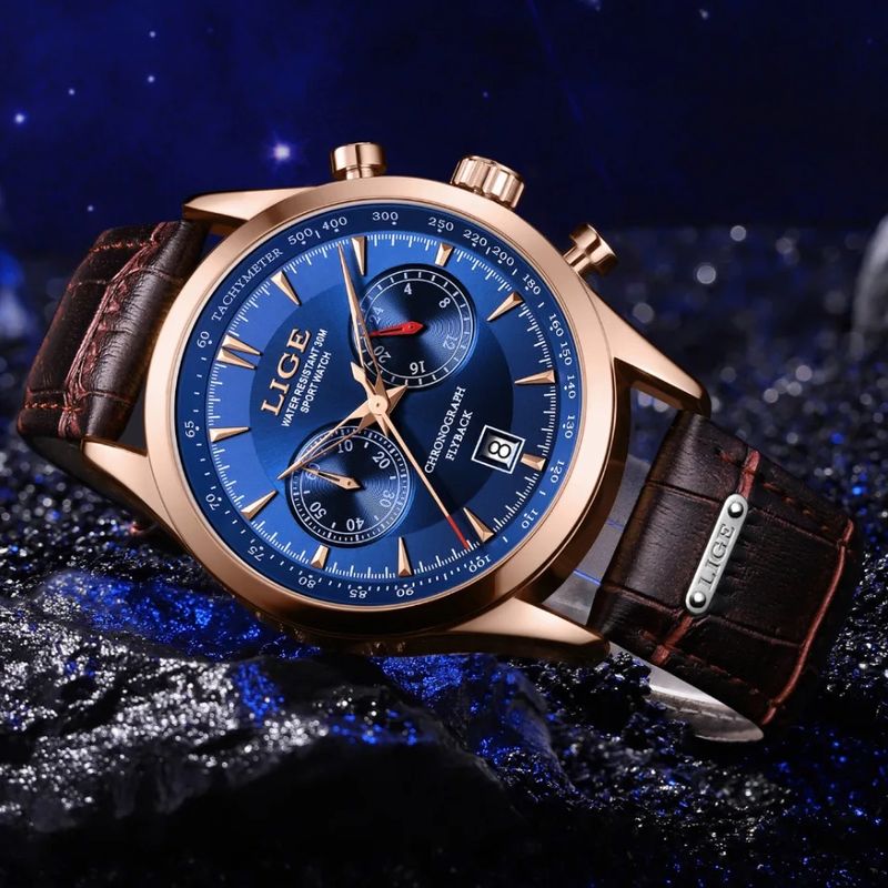 Montre Lige Chrono Flyback avec bracelet en cuir marron inclinée, reposant sur une pierre noire, son cadran bleu assorti d'un boitier et des aiguilles or - montre chronographe homme.