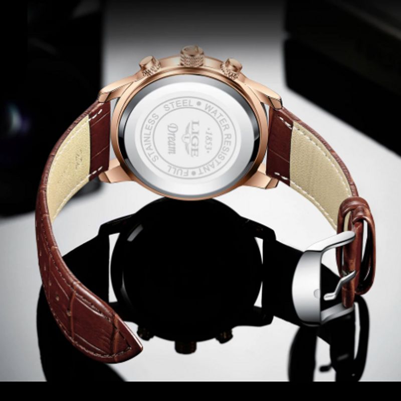 Montre Lige Design Pro pour homme, bracelet en cuir marron avec boucle ardillon, boîtier doré. Au verso sur le culot argenté, gravure en anglais : acier inoxydable, résistant à l'eau, rêve, Lige.