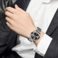 Montre à quartz Jordan avec cadran noir et bracelet argent en acier inoxydable de marque Lige sur le poignet d'un homme vêtu d'un costume gris et d'une chemise blanche