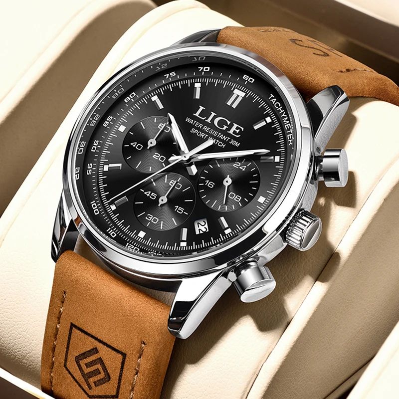 Montre LIGE Chrono Sport avec boîtier, aiguilles, index et chiffres romains argentés et cadran noir, son bracelet en cuir de couleur marron est enroulé autour d'un support en cuir beige.